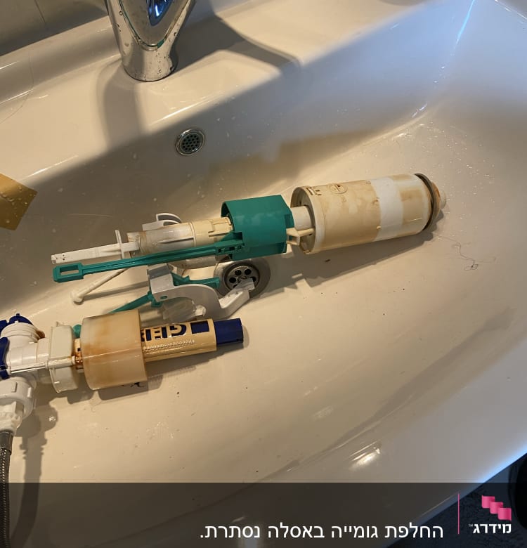 חלקי ברז וכלים בכיור לבן